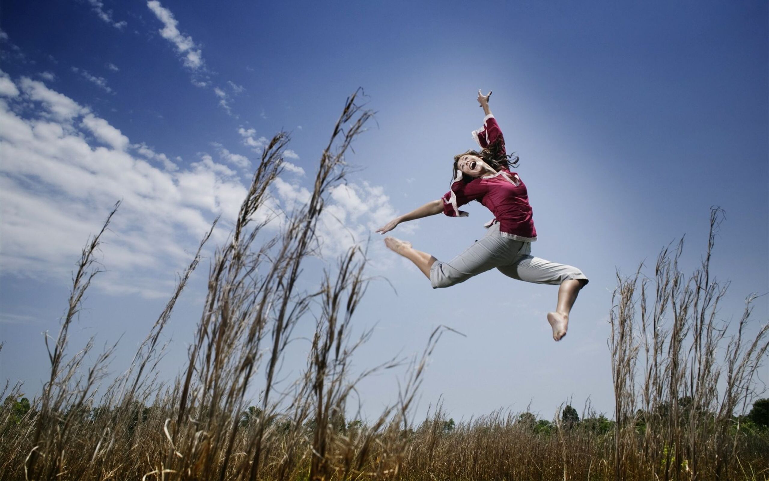 Прыгать кидать. Человек в прыжке. Прыжок в воздухе. Девушка в прыжке. Девушка прыгает в поле.