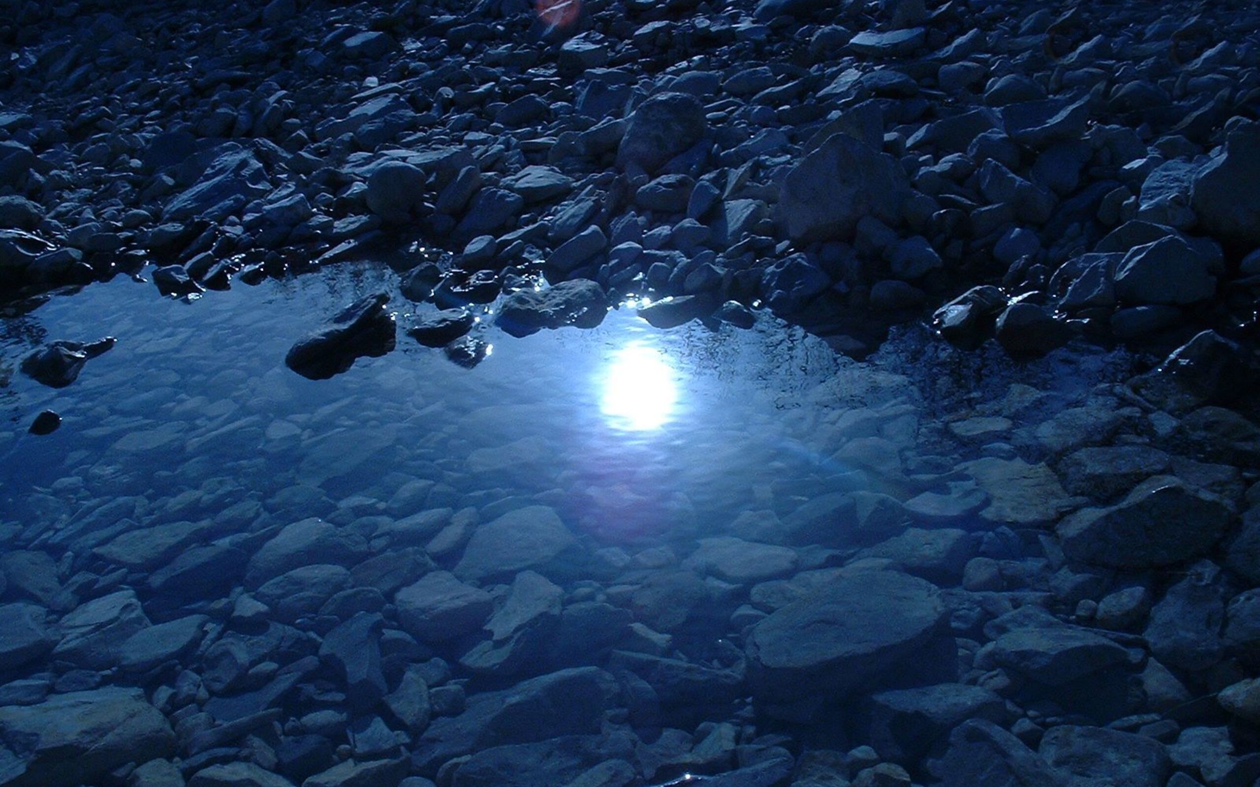 Луна распласталась на тихой воде. Камни под водой. Река под водой. Водная гладь ночью. Вода в темноте.